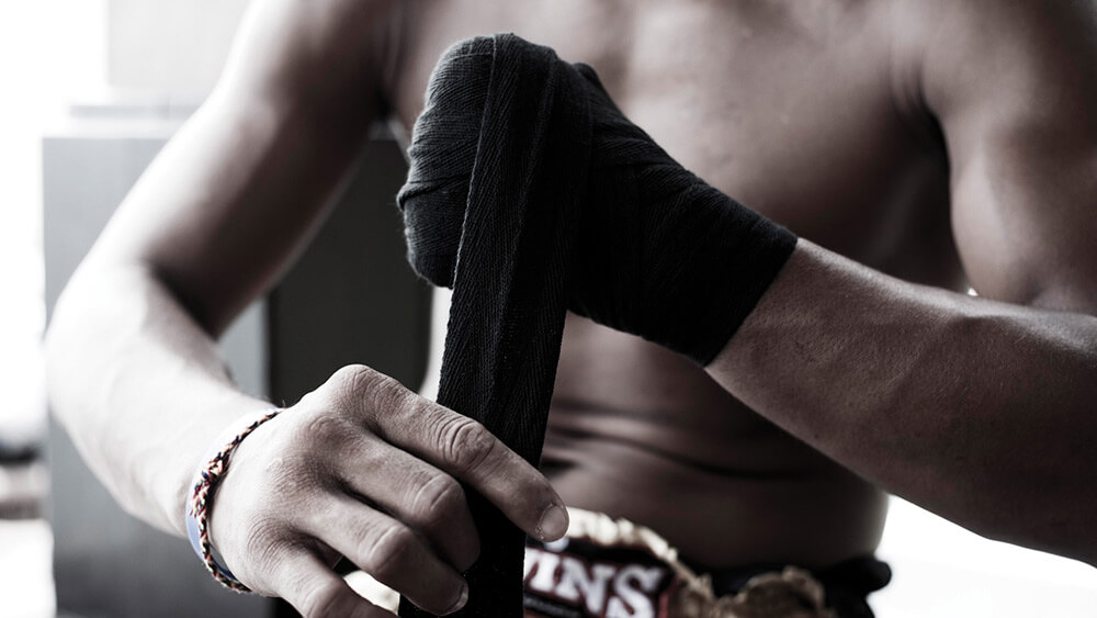 boxeador poniéndose un vendaje de boxeo en las manos para entrenar